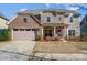 Charming brick and stone two-story home with a two-car garage and manicured front lawn at 11144 Limehurst Pl, Charlotte, NC 28278
