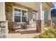Charming stone front porch featuring two wooden chairs, a small table, and a decorative wreath on the front door at 11144 Limehurst Pl, Charlotte, NC 28278