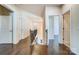 Open hallway featuring hardwood flooring, staircase with decorative railing, and multiple doorways at 11144 Limehurst Pl, Charlotte, NC 28278