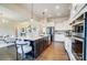 Modern kitchen with stainless steel appliances, white cabinets, island with seating and hardwood floors at 11144 Limehurst Pl, Charlotte, NC 28278