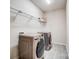 Functional laundry room with modern washer and dryer set, ample shelving, and tiled flooring at 11144 Limehurst Pl, Charlotte, NC 28278