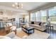 Bright and airy living room with hardwood floors, large windows, and seamless flow into the modern kitchen area at 11144 Limehurst Pl, Charlotte, NC 28278