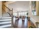 Open-concept living room with large windows, hardwood floors, stylish furniture, and view of the dining room and staircase at 11144 Limehurst Pl, Charlotte, NC 28278