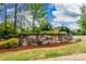 Chapel Cove stone community sign surrounded by vibrant flowers, greenery, and lush landscaping with bright blue skies at 11144 Limehurst Pl, Charlotte, NC 28278