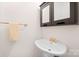 Close-up of charming half-bath with pedestal sink and dark wood cabinet at 1205 Scaleybark Rd # A, Charlotte, NC 28209