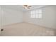 Spacious bedroom with carpet, ceiling fan, and large shuttered window at 1205 Scaleybark Rd # A, Charlotte, NC 28209