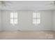 Large carpeted bedroom with dual windows and ceiling fans at 1205 Scaleybark Rd # A, Charlotte, NC 28209