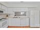 Bright kitchen features white cabinetry, tile countertops, and an open layout into the living area at 1205 Scaleybark Rd # A, Charlotte, NC 28209