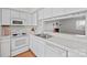 Bright kitchen features white cabinetry, tile countertops, and an open layout into the living area at 1205 Scaleybark Rd # A, Charlotte, NC 28209