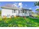 Exterior view of sunroom, landscaping, and a lush backyard with mature trees offering privacy and an inviting outdoor space at 130 Atwell Rd, Mt Ulla, NC 28125