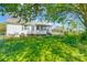 Exterior view of home, featuring a sunroom, carport, and lush backyard with mature trees, providing a private retreat at 130 Atwell Rd, Mt Ulla, NC 28125