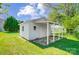 Outbuilding featuring white siding, covered porch area, and mature shade trees adding character and functionality to the property at 130 Atwell Rd, Mt Ulla, NC 28125