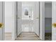 An open doorway to a bathroom reveals marble floors and a bright window over a soaking tub at 13833 Jonathans Ridge Rd, Mint Hill, NC 28227