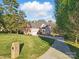 The house sits on a lush green lawn with mature shade trees, a beautiful driveway, and brick mailbox at 13833 Jonathans Ridge Rd, Mint Hill, NC 28227