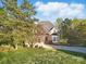 A well-maintained front exterior featuring brick accents, a bay window, and a lush green lawn at 13833 Jonathans Ridge Rd, Mint Hill, NC 28227