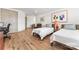 Bright bedroom featuring hardwood floors, two beds, and colorful abstract art at 1447 Encore Ln, Waxhaw, NC 28173