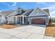 Charming home featuring a two-car garage, covered porch, and manicured front lawn at 1447 Encore Ln, Waxhaw, NC 28173