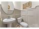 Stylish half bath with wainscoting and a round mirror at 1447 Encore Ln, Waxhaw, NC 28173