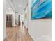 Long hallway with hardwood flooring, neutral walls, and multiple framed paintings on the wall at 1447 Encore Ln, Waxhaw, NC 28173