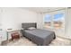 Bright bedroom with a gray bed, a modern desk, and large windows at 15616 Parkside Crossing Dr, Charlotte, NC 28278
