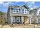 Attractive two-story home with a bright yellow door, complemented by blossoming trees at 15616 Parkside Crossing Dr, Charlotte, NC 28278