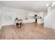 Bright, open-concept living area with hardwood floors connecting the dining and kitchen spaces at 15616 Parkside Crossing Dr, Charlotte, NC 28278