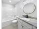 Bright bathroom features a tub and a round mirror over the marble countertop vanity at 1638 Pineburr Ln, Rock Hill, SC 29730