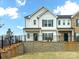 Modern two-story townhome featuring a classic design and a well-maintained front yard with black fencing at 1814 Saint Louis Nw Aly, Concord, NC 28027
