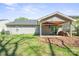 View of the backyard with covered patio, mature landscaping, and level lawn at 1838 Summit Ridge Ln, Kannapolis, NC 28083