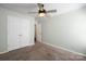 Neutral bedroom featuring a ceiling fan, a closet with double doors, and tan carpet at 1838 Summit Ridge Ln, Kannapolis, NC 28083