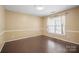 A cozy bedroom with hardwood floors, white trim, and a large window at 1838 Summit Ridge Ln, Kannapolis, NC 28083