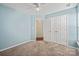 Bedroom featuring blue walls, neutral carpet, and a double door closet at 1838 Summit Ridge Ln, Kannapolis, NC 28083