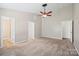 Carpeted main bedroom showcasing a ceiling fan, three doorways, and neutral paint at 1838 Summit Ridge Ln, Kannapolis, NC 28083