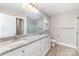 Bathroom with double sink vanity, granite countertop, gray walls, wood-look flooring, and glass shower at 206 W 19Th St, Kannapolis, NC 28081