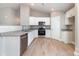 Bright kitchen features stainless steel appliances, gray granite countertops, white cabinets, and wood-look flooring at 206 W 19Th St, Kannapolis, NC 28081