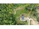 A bird's eye view of the home shows the surrounding treed acreage and the property's gravel driveway at 253 Artemis Pl # 27, Kershaw, SC 29067