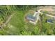 An aerial view showcases the home, a gravel driveway and the surrounding treed and natural setting at 253 Artemis Pl # 27, Kershaw, SC 29067