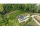 An aerial view showcases the home, a gravel driveway and the surrounding treed and natural setting at 253 Artemis Pl # 27, Kershaw, SC 29067