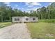 Charming single-story home with gray siding, black shutters, and a gravel driveway surrounded by lush greenery at 253 Artemis Pl # 27, Kershaw, SC 29067
