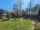 Well-maintained backyard featuring a lush lawn, mature trees, and a privacy fence at 2741 Smethwick Ln, Gastonia, NC 28056
