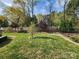 Lush backyard featuring mature trees, green grass, and privacy fencing, creating a serene outdoor space at 2741 Smethwick Ln, Gastonia, NC 28056