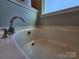 Close-up of soaking tub with chrome fixtures and window at 2741 Smethwick Ln, Gastonia, NC 28056