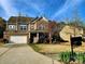 Charming two-story home featuring a brick and siding exterior, manicured lawn, and an attached two-car garage at 2741 Smethwick Ln, Gastonia, NC 28056