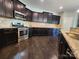 Modern kitchen with stainless steel appliances, dark cabinets, and granite countertops at 2741 Smethwick Ln, Gastonia, NC 28056
