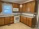 Traditional kitchen with wood cabinets, white appliances, and a light-colored countertop at 307 Gold Hill Ave, Rockwell, NC 28138