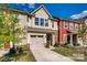 Charming townhome with attached garage, stone accents and landscaped yard on a beautiful partially cloudy day at 319 Pond Place Ln, Matthews, NC 28104