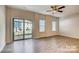 Open-concept living room with lots of natural light, ceiling fan, and sliding glass door to the back yard at 319 Pond Place Ln, Matthews, NC 28104