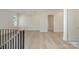 Hallway featuring a stairway, hardwood floors, and white walls with white trim at 3200 Providence Rd # 1B, Charlotte, NC 28211