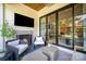 Cozy outdoor living space with fireplace, TV, comfortable seating, and sliding glass doors leading indoors at 3200 Providence Rd # 1B, Charlotte, NC 28211