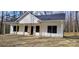 A modern home with white siding, black trim, a covered porch, and stone skirting at 330 Fiber Acres A St, Cleveland, NC 27013